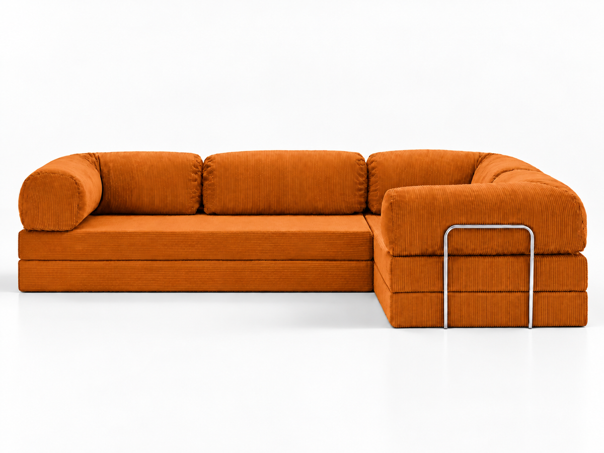 A straight-on product view of the Confex Corner Orange Sofa against a white background shows its long cushioned seat, rounded armrests and projecting corner section on the right side of the image.
