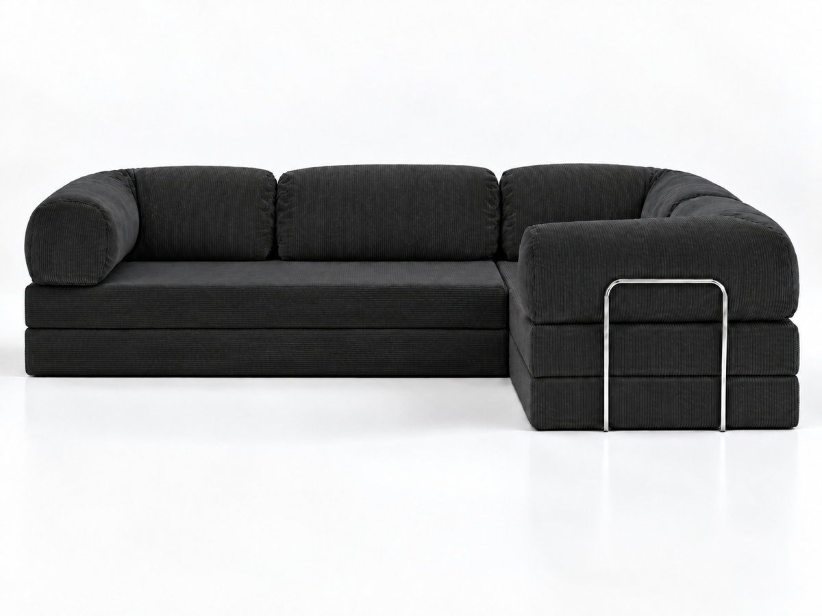 The Confex Corner Black Sofa is presented head-on against a white studio background, showing three back cushions, curved outer arms and a right-hand projecting section with contrasting metal trim.