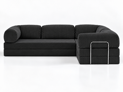 The Confex Corner Black Sofa is presented head-on against a white studio background, showing three back cushions, curved outer arms and a right-hand projecting section with contrasting metal trim.