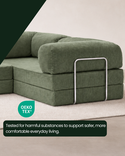 Close-up of the Confex Corner Green Sofa highlighting its olive green ribbed corduroy fabric, visible stitching, rounded armrest construction and distinctive upholstered texture.